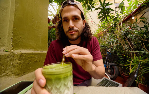 Man drinking green beverage at caf&eacute; in Vietnam