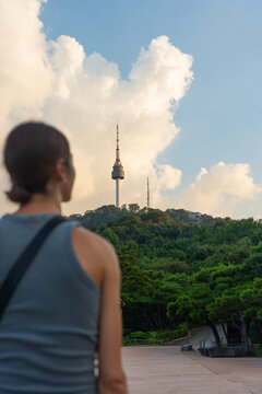 Visitor Admires N Seoul Tower From the Base in Warm Daylight