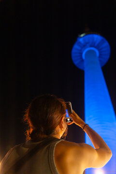 Person Taking Photo of Blue-Lit N Seoul Tower at Night