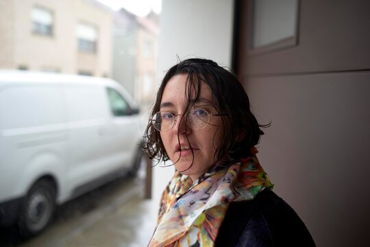 Woman With Wet Hair Standing by a Snowy Van in a City Street
