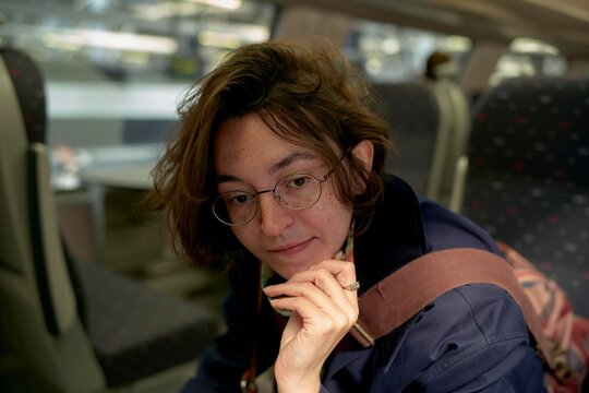 Woman Resting on Train During Busy Travel in the City