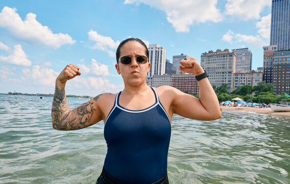 Woman flexing arms in water at Chicago beach