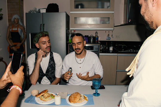 Friends enjoying snacks and drinks at a cozy kitchen table