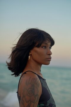 Woman by the Water Reflecting at Sunset With Gentle Waves