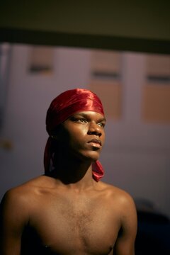 Man Wearing a Red Scarf Looks Thoughtfully Into the Distance