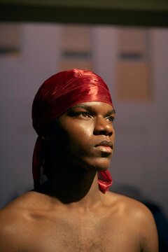 Man in Red Headscarf Gazes Thoughtfully Into Distance