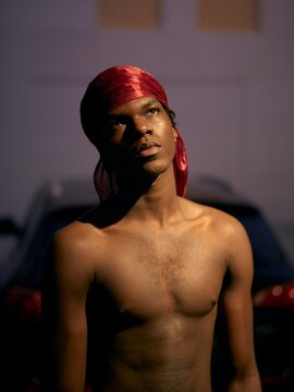 Young Man Gazes Upwards at Night in Urban Setting