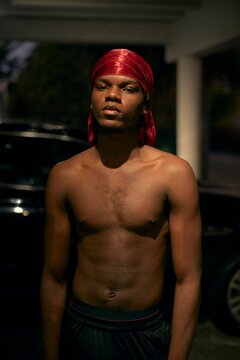 Young Man With Red Durag Poses Confidently at Night