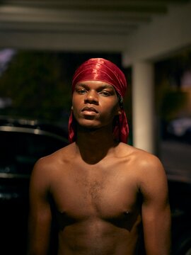 Young Man With Red Do-Rag Poses at Dusk in a Parking Area