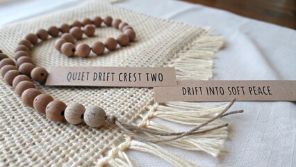 Fototapeta premium Calm Wooden Beads with Tranquil Labels on Natural Textile Surface for Peaceful Decor and Mindfulness Meditation