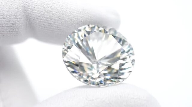 Gloved Hand Holding Round Brilliant Diamond.