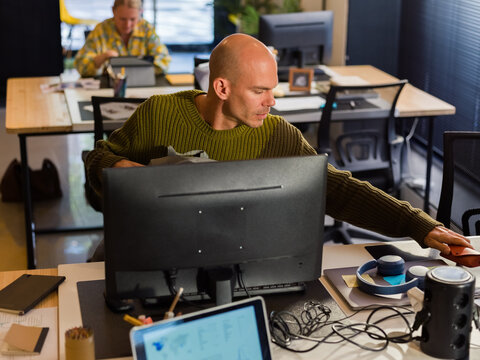 Office Worker Organizing Workspace During a Busy Day