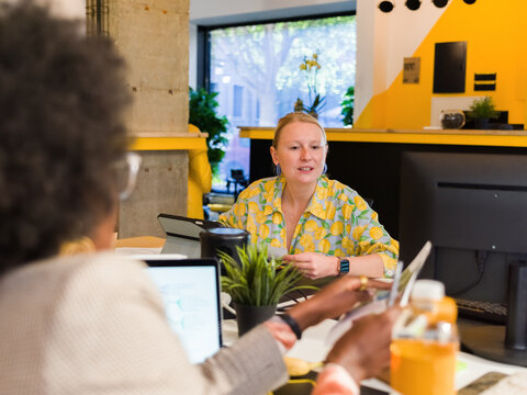 Businesswoman showing document to colleague