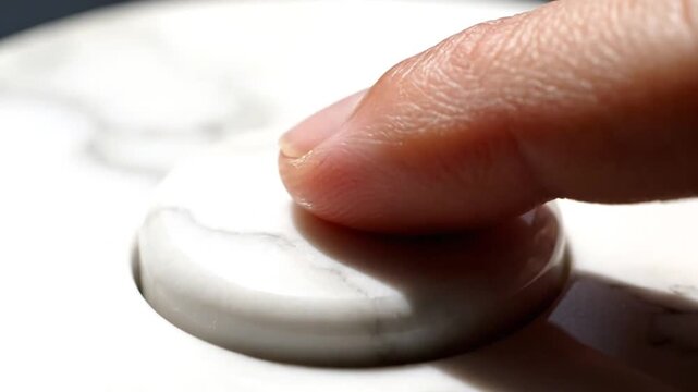 Hand Pressing Cream on Marble Surface.