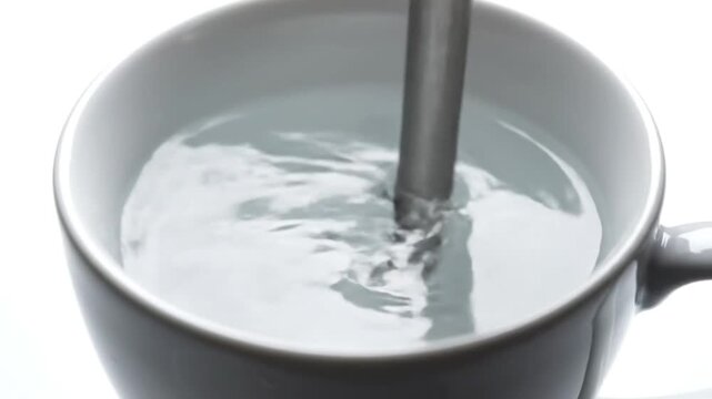 Milk Being Stirred in White Mug.