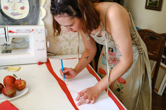 a woman cutting clothes on a table