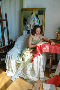 A woman flips through a notebook while sitting in a chair