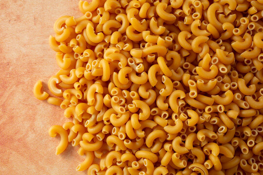 A top down view of a pile of dry gluten-free elbow pasta.