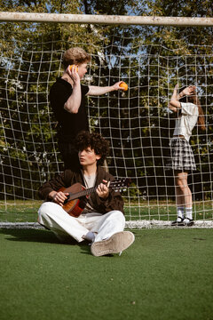 Playing music while friends enjoy soccer practice