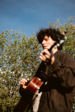 Guitar player enjoys sunny day in the park
