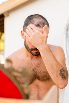 Young man with a buzzcut checking himself in the mirror