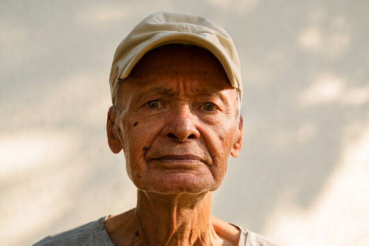 Senior man wearing a cap and gray t-shirt looking at camera
