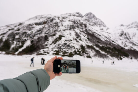 Handheld Device Capturing a Snowy Landscape and People Skating