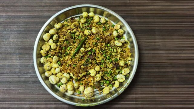 homemade poha chivda snack mix with sev peanuts and spices in round steel dish
