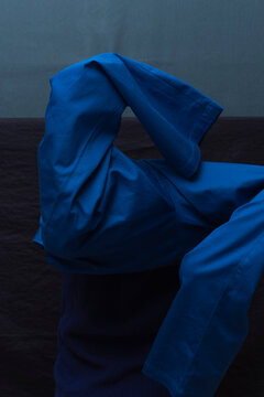 Man Dressing in Blue Against Tonal Backdrop