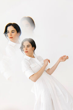 Woman dancing in white dress creating movement effect