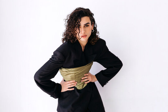 Queer man posing wearing blazer and corset 