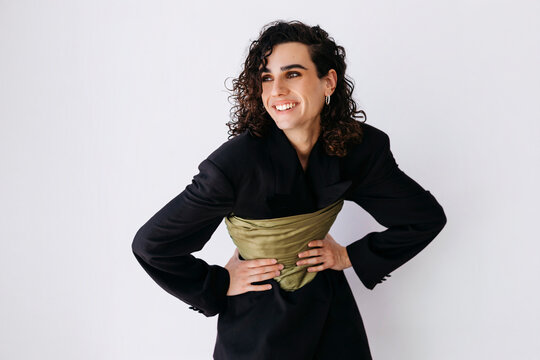 Queer man with curly hair smiling.