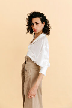 Queer man posing in studio with neutral background