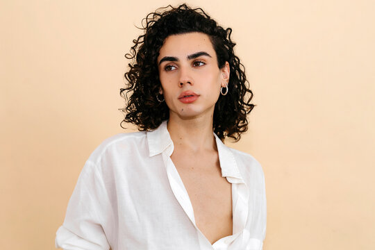 Queer man posing looking away in studio