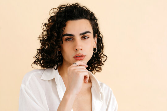 Queer man posing with hand on chin