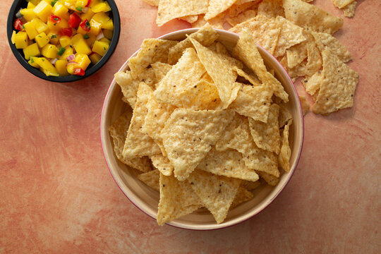 A top down view of a bowl of white corn tortilla chips.