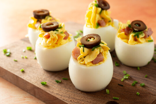A view of some deviled eggs, on a wood board.