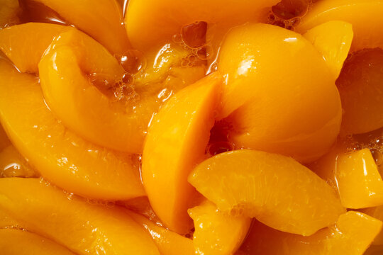 A top down view of a pile of canned peaches, as a background.