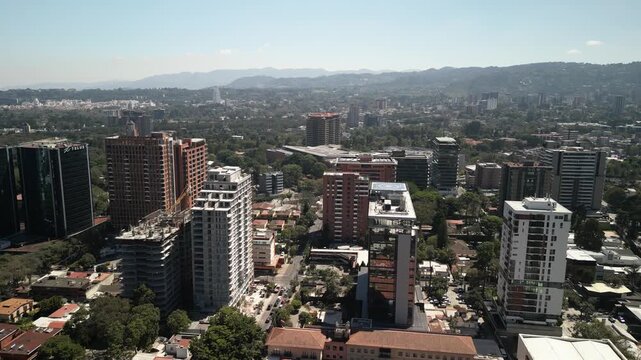 Aerial fly forward over skyscrapers in downtown Guatemala City zona 14