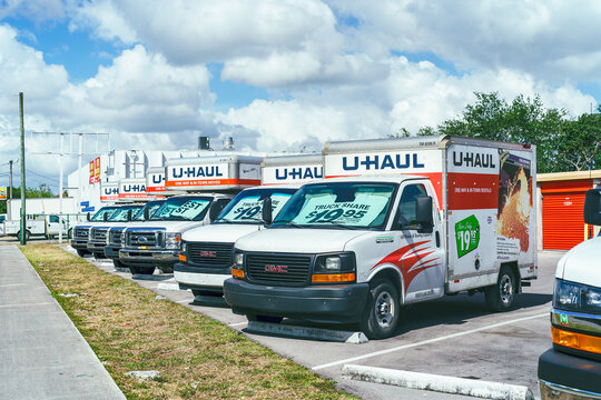 miami,usa, May 02,2025. a parked U-Haul truck in a parking lot, with other similar trucks to its left and a row of storage units to its right.