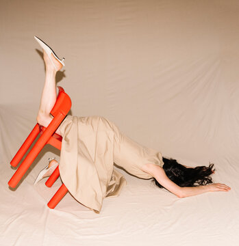 Beige Dress On Red Chair Surreal Pose