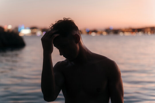 Silhouette of shirtless man at the beach
