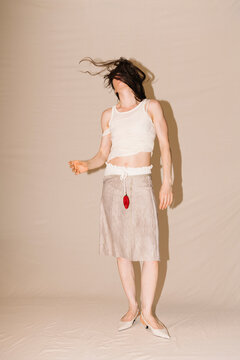 Dancer In Beige Dress With Red Pendant