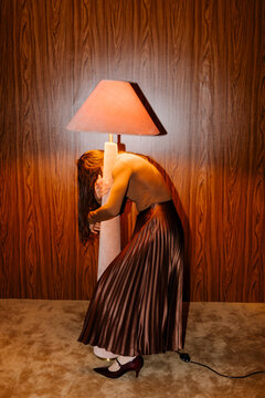 Surreal Embrace With Oversized Lamp In Vintage Room