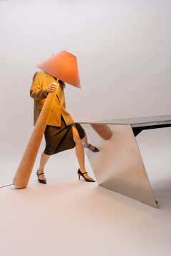 Surreal Fashion Pose With Cone Hat and Table