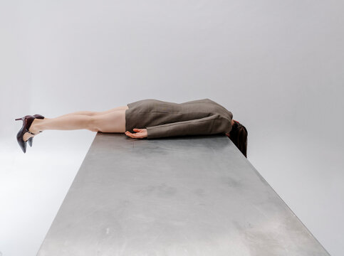 Businessperson Leaning Over Edge On Metal Table