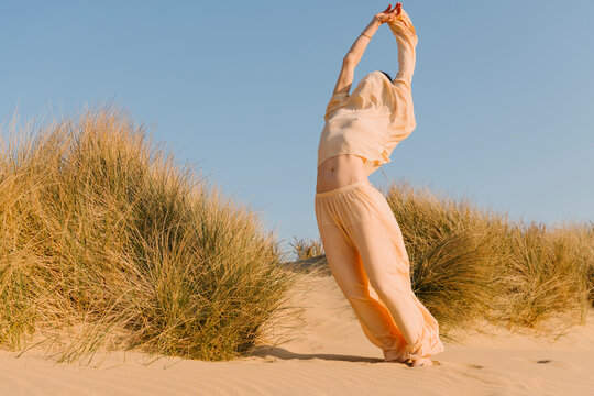 Stretching Sunrise Pose On Desert Dunes
