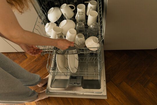 Top View of Dishwasher Shelf Being Loaded with Dirty Dishes