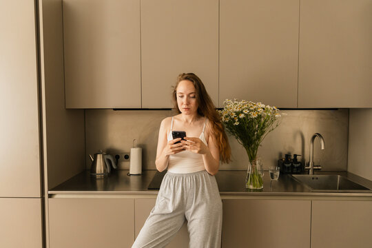 Close-Up of Woman on Phone in Modern Kitchen