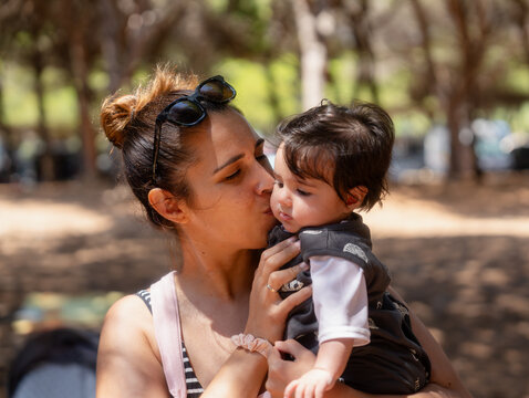 Mother kissing her baby expressing love and affection
